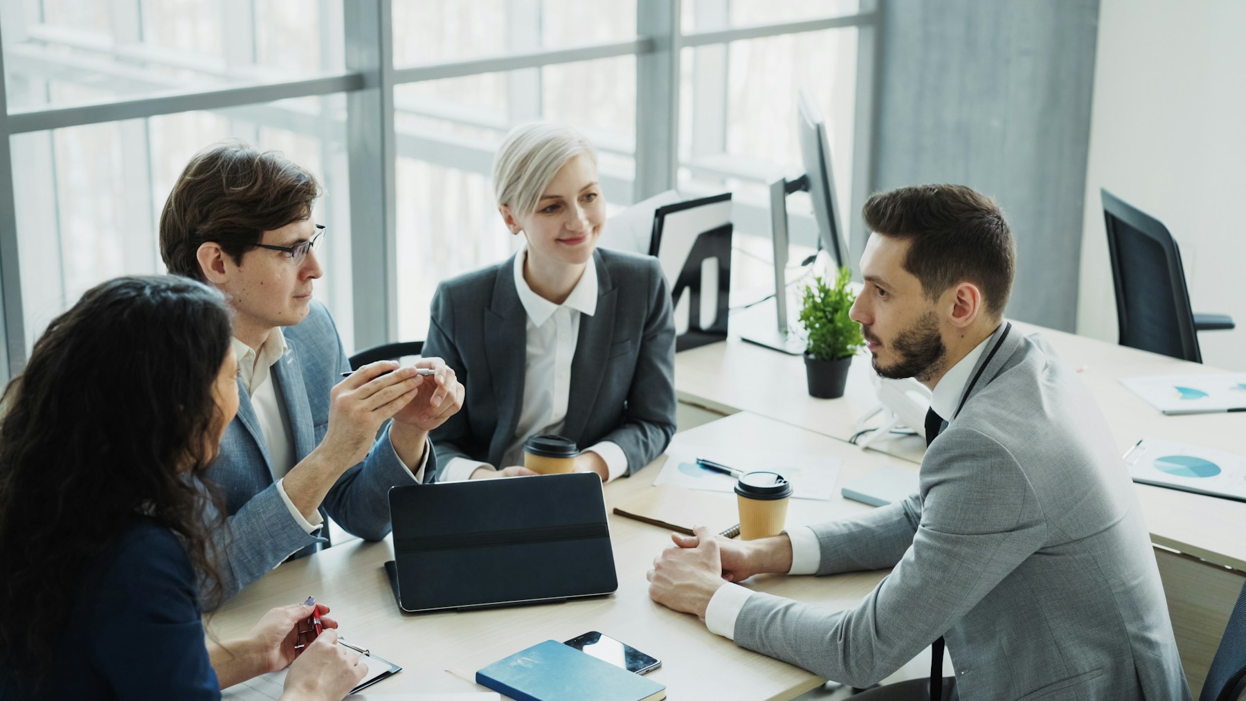 Equipo de profesionales revisa documentos durante una reunión corporativa
